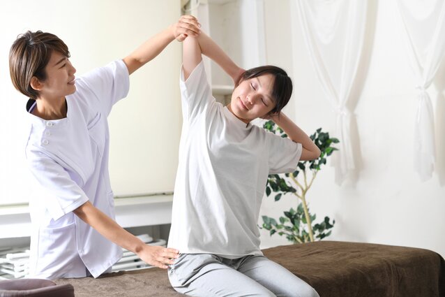 オフィスで肩のストレッチをしている女性
